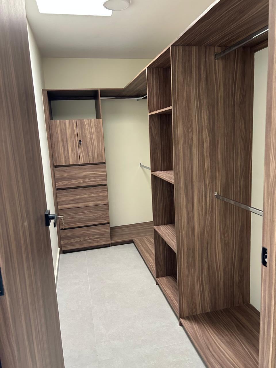 Interior de vestidor de madera con entrepaños y cajones